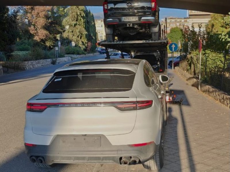 Porsche Cayenne and SUV loaded on a vehicle transporter for repatriation